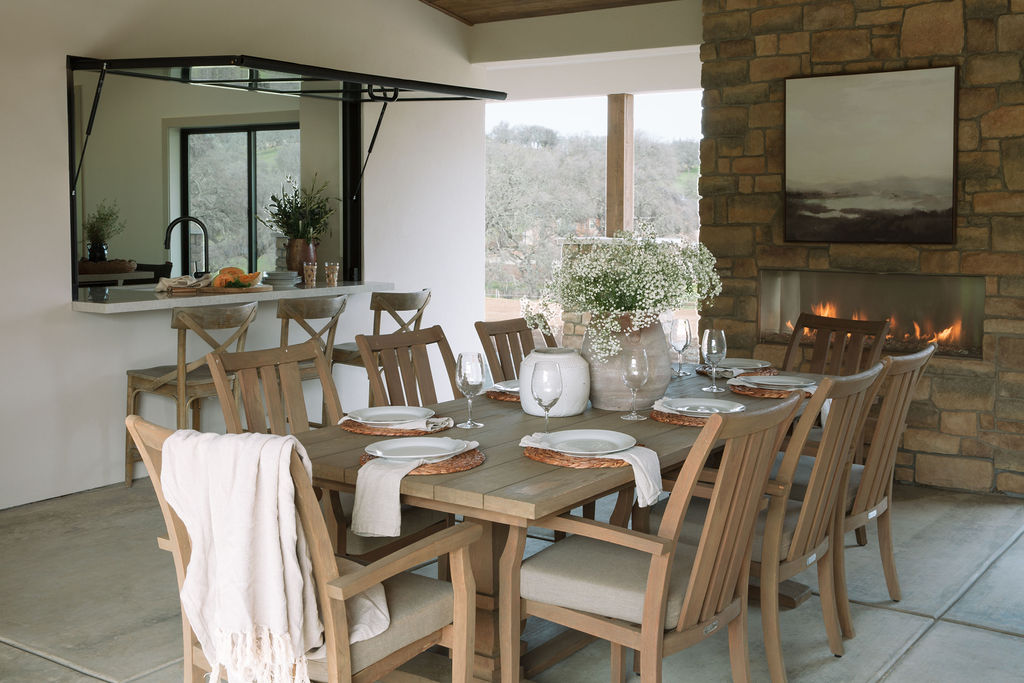 Interior designed dining room in Sacramento CA with glass open door from kitchen, brick fireplace and wooden table