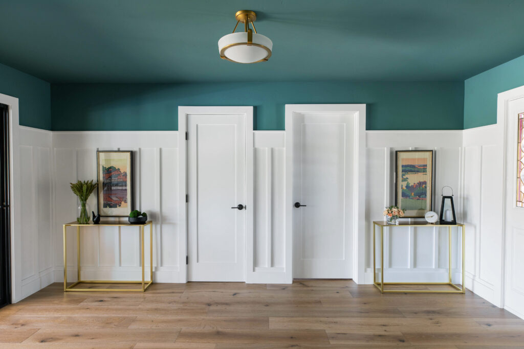 Interior designed hallway with white custom millwork, gold and glass side tables in Sacramento CA. Green paint on ceiling and top of walls. Jennifer Ramsey Interiors.